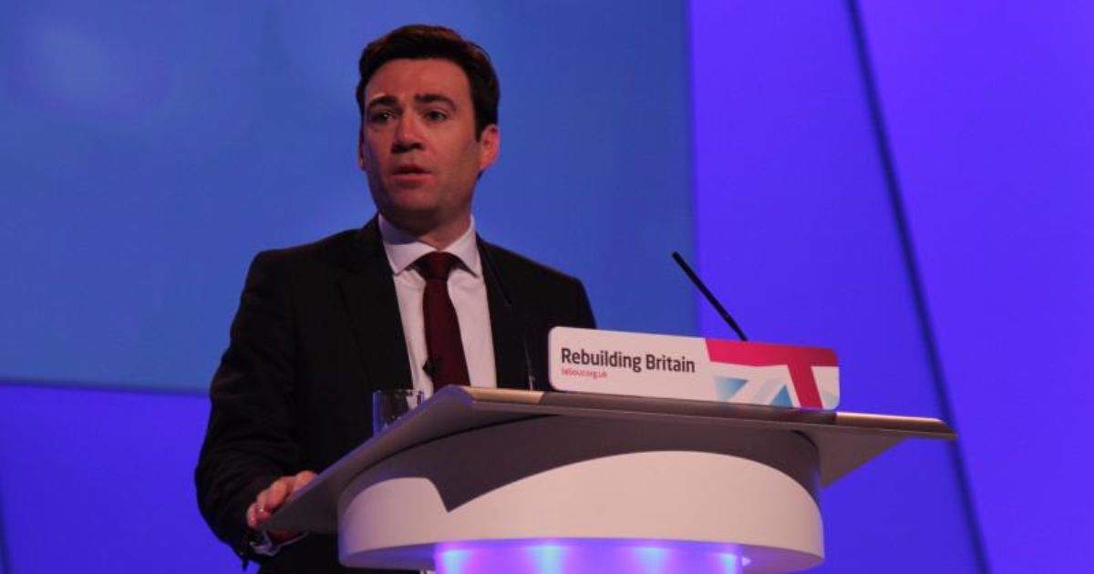 Andy Burnham standing at a lectern during his time as a politician
