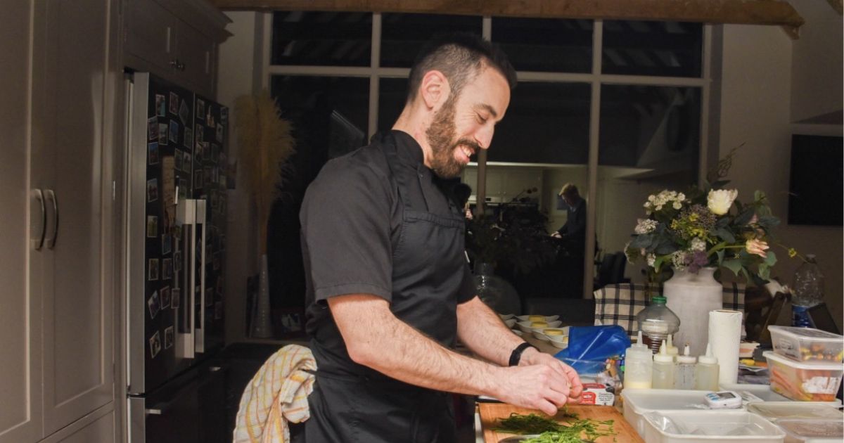 Mark Weeks smiling as he prepares food